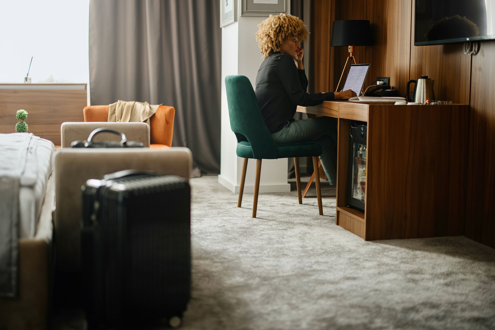 Mujer de negocios trabajando en una computadora portátil en la habitación del hotel